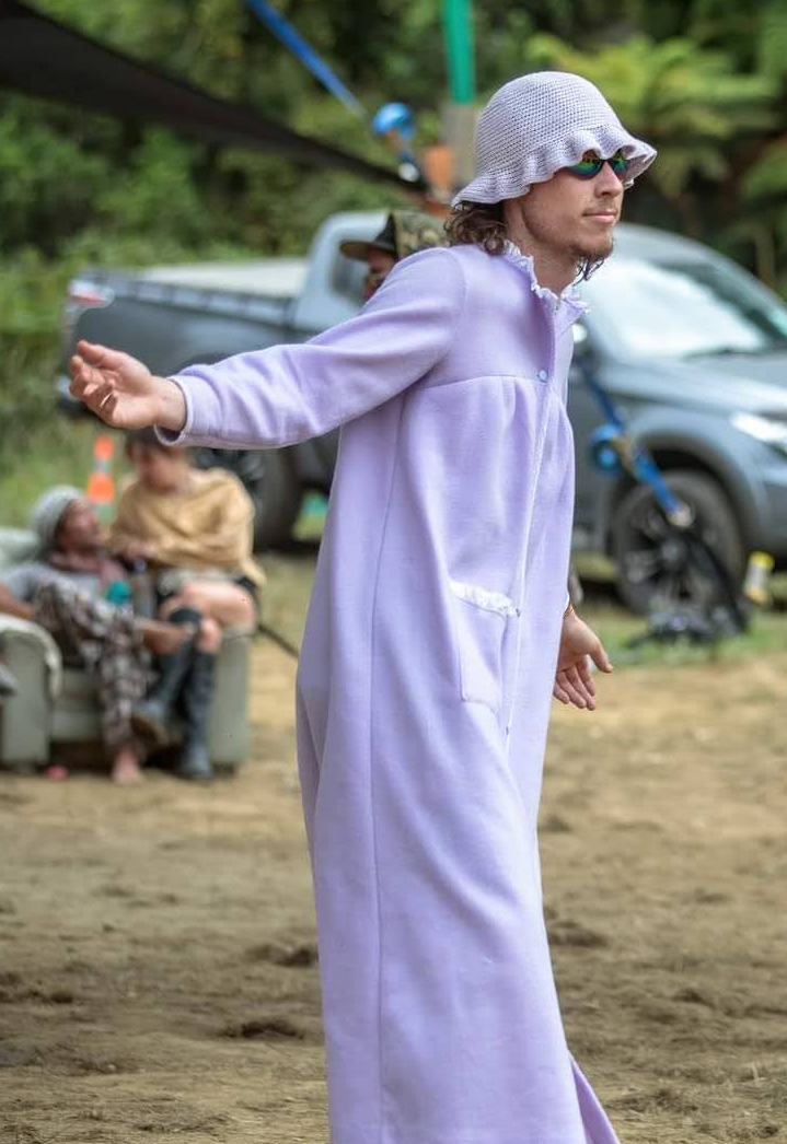 Portrait of Lachie, founder of Slypork Studio, donned in lilac and enjoying a hi-tech morning at Twisted Frequency festival.